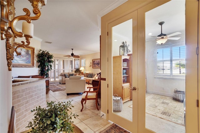 hall with french doors, crown molding, and light tile patterned flooring