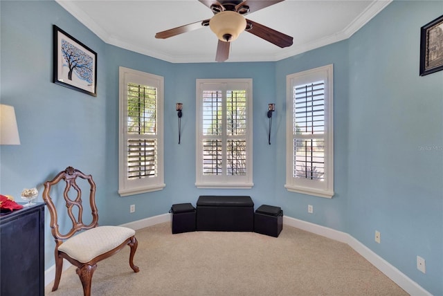 sitting room with carpet flooring, ceiling fan, and ornamental molding