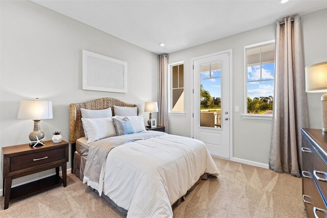 bedroom featuring access to exterior and light carpet