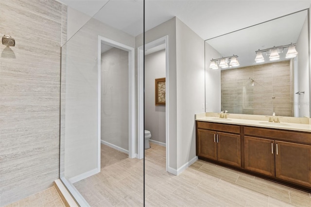 bathroom featuring vanity, toilet, and tiled shower