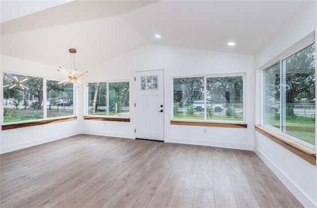 unfurnished sunroom featuring an inviting chandelier, vaulted ceiling, and plenty of natural light