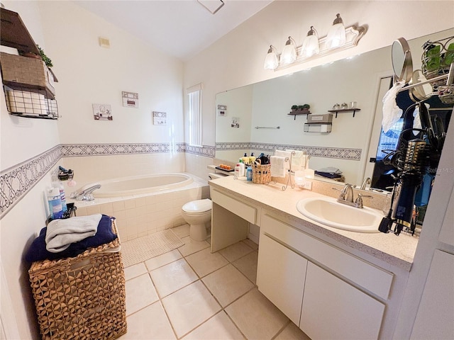 bathroom with tile patterned floors, vanity, vaulted ceiling, a relaxing tiled tub, and toilet