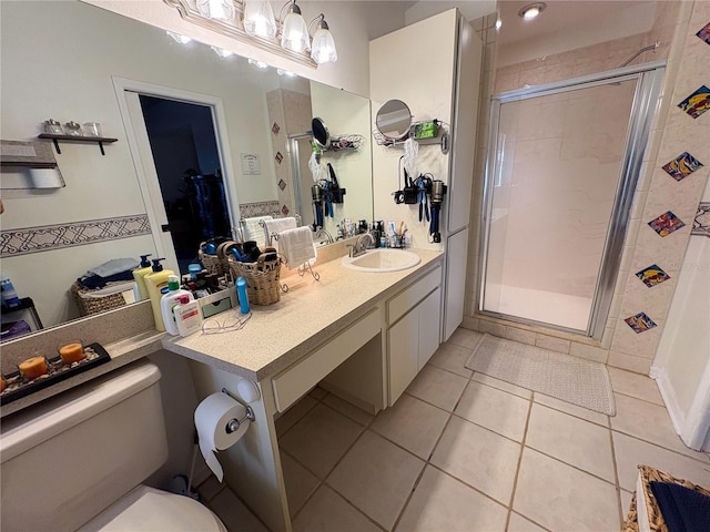 bathroom featuring toilet, a shower with door, vanity, and tile patterned flooring