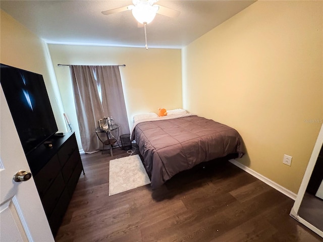 bedroom with dark hardwood / wood-style floors and ceiling fan