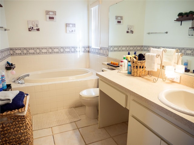 bathroom featuring tile patterned floors, tiled bath, vanity, and toilet