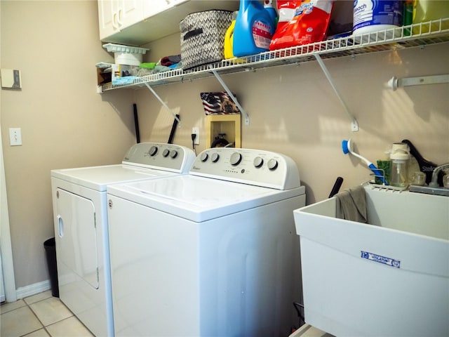 laundry area with washer and clothes dryer, light tile patterned floors, and sink