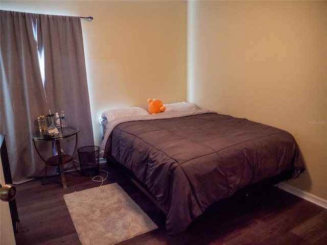 bedroom with dark wood-type flooring