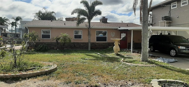 exterior space featuring central AC unit, a carport, and a lawn