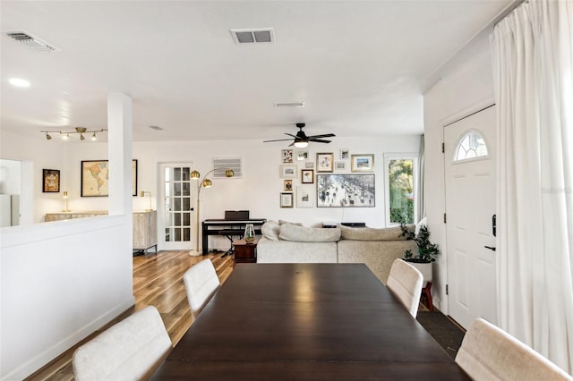 dining space with ceiling fan and wood-type flooring