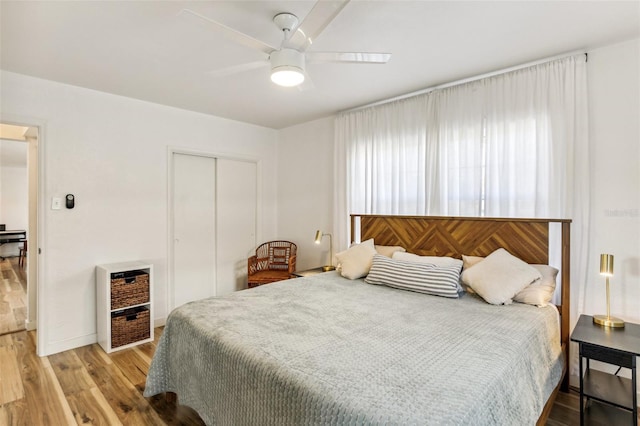 bedroom with ceiling fan, a closet, and light hardwood / wood-style flooring