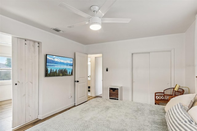 bedroom featuring heating unit, ceiling fan, and hardwood / wood-style floors