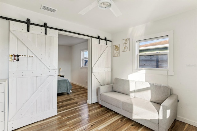 sitting room featuring hardwood / wood-style floors, a barn door, and a wealth of natural light