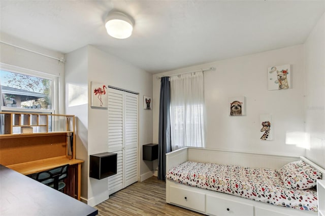 bedroom with light wood-type flooring and a closet