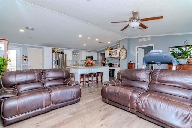 living room featuring ceiling fan, lofted ceiling, crown molding, and light hardwood / wood-style flooring