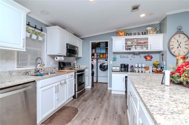 kitchen featuring sink, washer and clothes dryer, white cabinets, and appliances with stainless steel finishes