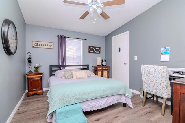 bedroom with ceiling fan, light wood-type flooring, and vaulted ceiling