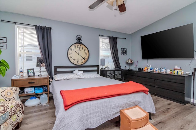 bedroom featuring ceiling fan, lofted ceiling, light wood-type flooring, and multiple windows