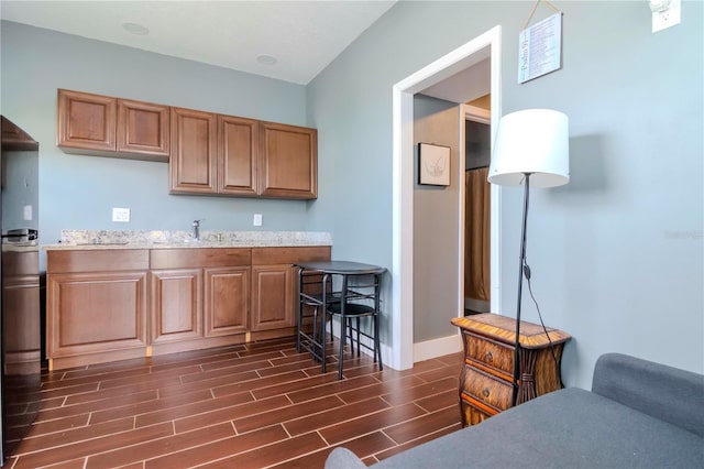 kitchen featuring light stone countertops and sink