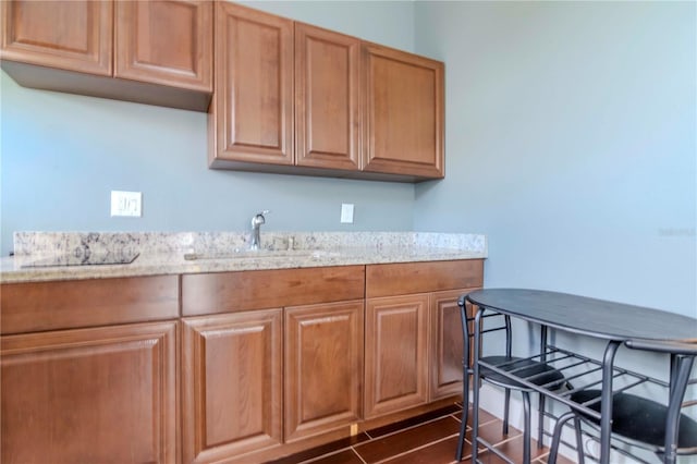 kitchen with light stone counters, sink, and dark hardwood / wood-style floors