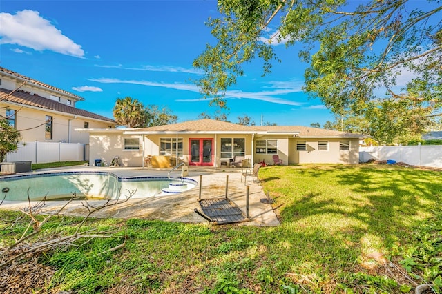 back of house featuring a yard, a fenced in pool, and a patio area