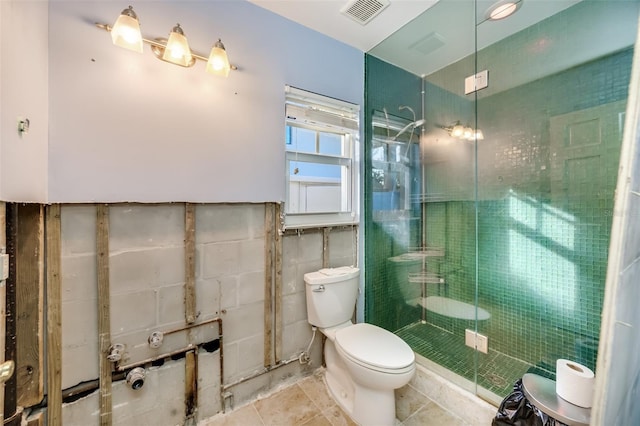 bathroom with tile patterned flooring, a shower with shower door, tile walls, and toilet