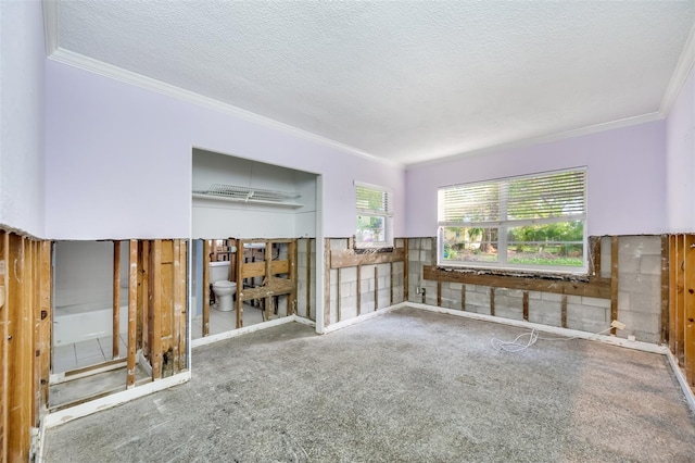 unfurnished room with carpet floors, a textured ceiling, and ornamental molding