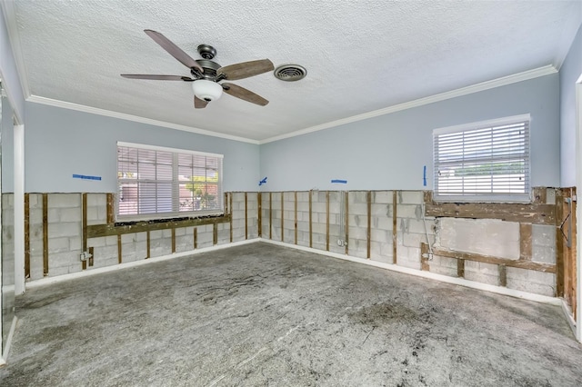 carpeted spare room featuring plenty of natural light, ceiling fan, crown molding, and a textured ceiling