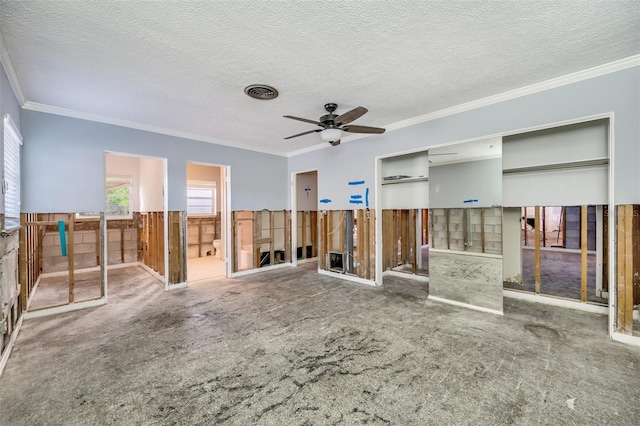 carpeted spare room with ceiling fan, crown molding, a textured ceiling, and wooden walls