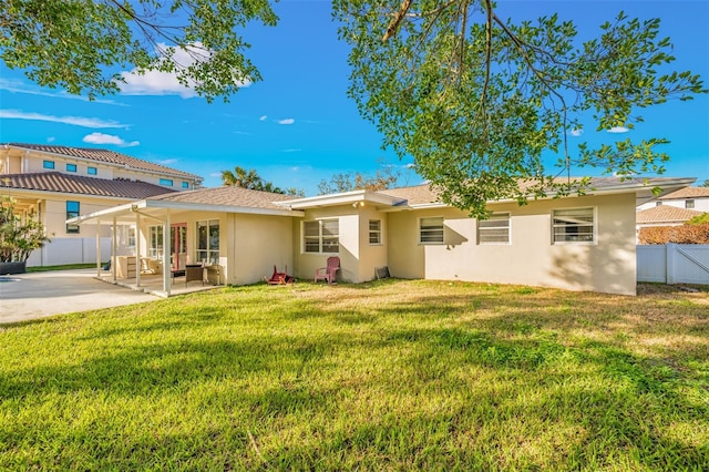 rear view of house featuring a lawn, a patio area, and an outdoor hangout area