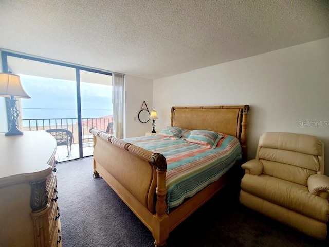 carpeted bedroom featuring a textured ceiling, a wall of windows, a water view, and access to outside