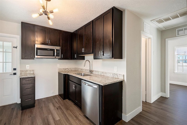 kitchen featuring sink, dark brown cabinetry, stainless steel appliances, and dark wood-type flooring