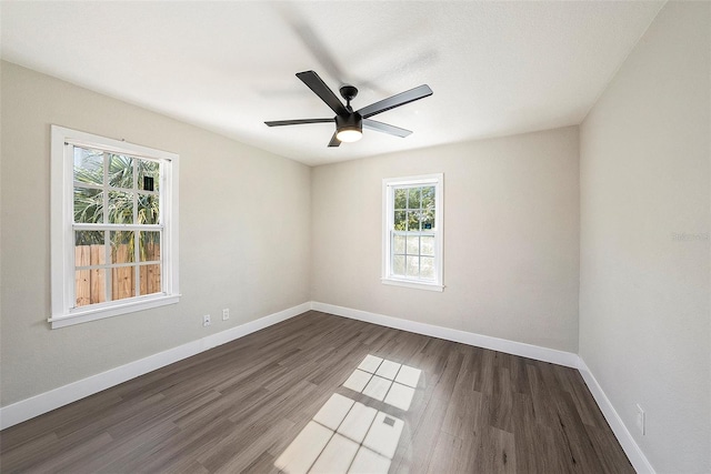 spare room featuring a wealth of natural light, dark wood-type flooring, and ceiling fan