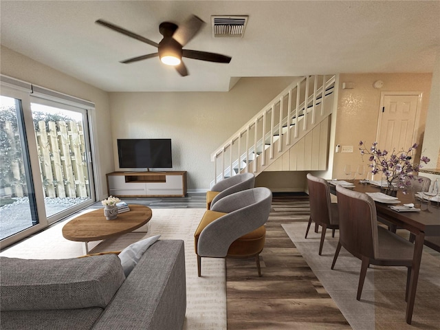 living room featuring ceiling fan and dark hardwood / wood-style flooring