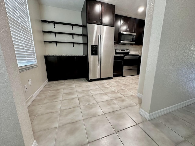 kitchen with dark brown cabinetry, appliances with stainless steel finishes, decorative backsplash, and light tile patterned floors