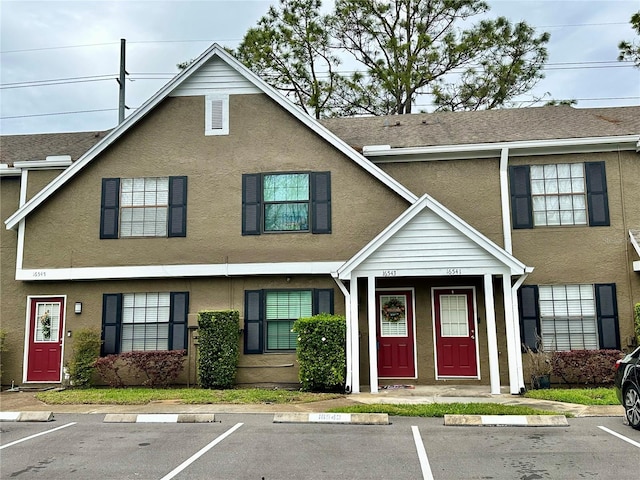 view of property featuring stucco siding and uncovered parking