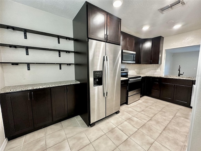 kitchen featuring visible vents, open shelves, appliances with stainless steel finishes, decorative backsplash, and light stone countertops