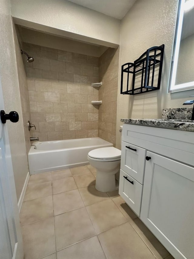 bathroom featuring vanity, bathing tub / shower combination, tile patterned floors, toilet, and a textured wall