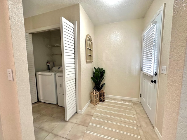 laundry area with washing machine and clothes dryer, laundry area, and a textured wall