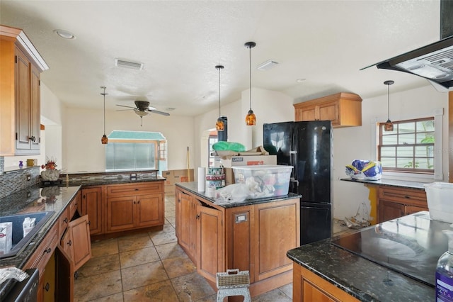 kitchen with a center island, hanging light fixtures, black appliances, and ceiling fan