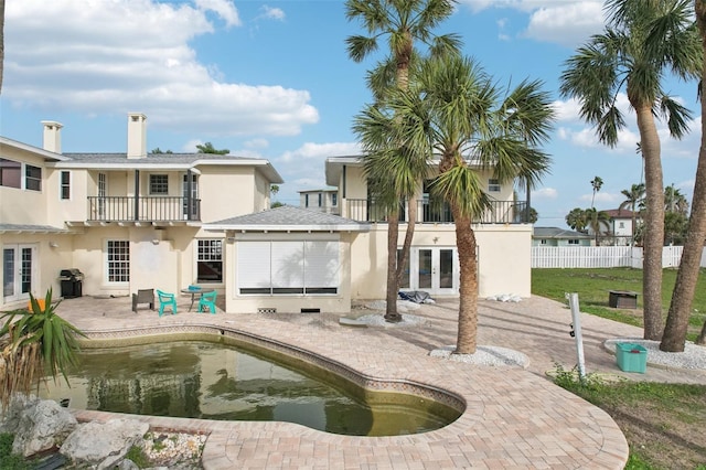 back of house with a balcony, a patio, and french doors