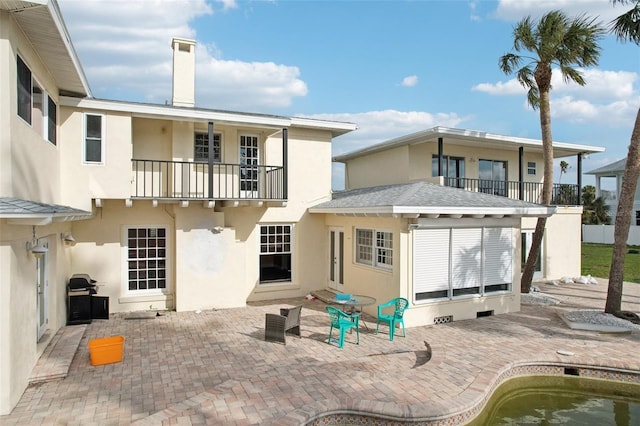 rear view of property with a patio and a balcony