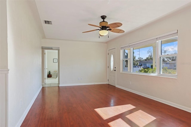 empty room with dark hardwood / wood-style flooring and ceiling fan