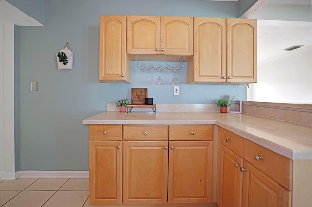 kitchen with light brown cabinets and light tile patterned flooring