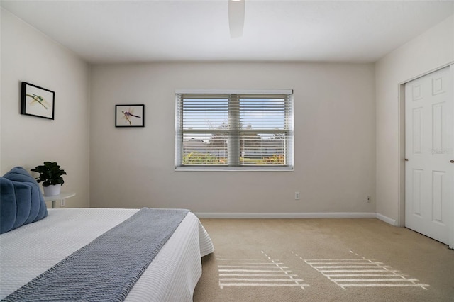 carpeted bedroom featuring ceiling fan and a closet