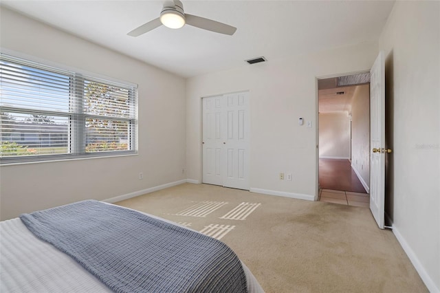 carpeted bedroom with a closet and ceiling fan