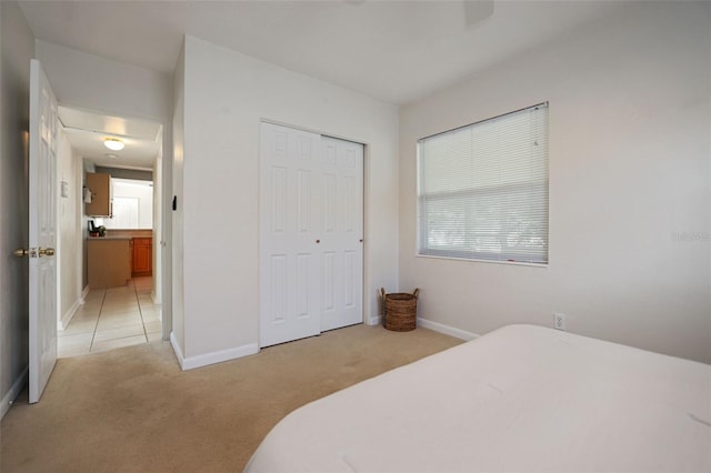 bedroom with light carpet and a closet