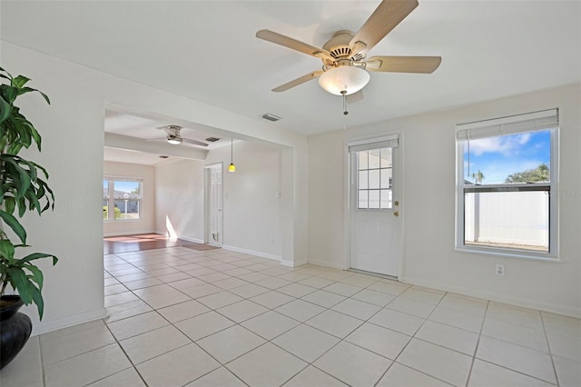 tiled empty room featuring ceiling fan