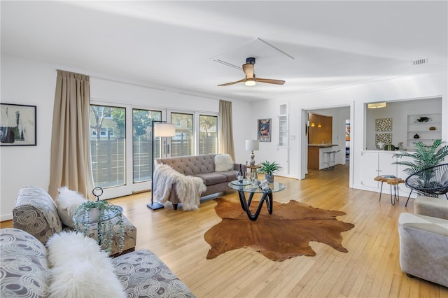 living room with ceiling fan, light hardwood / wood-style floors, and built in features