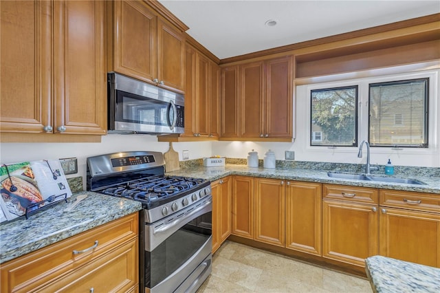 kitchen with light stone counters, sink, and appliances with stainless steel finishes