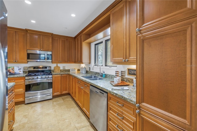 kitchen featuring sink, light stone countertops, and stainless steel appliances